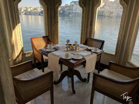 a table set for two with chairs and a view of the water