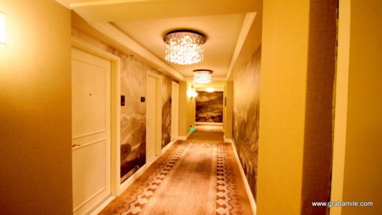 a hallway with a chandelier and a wall painting