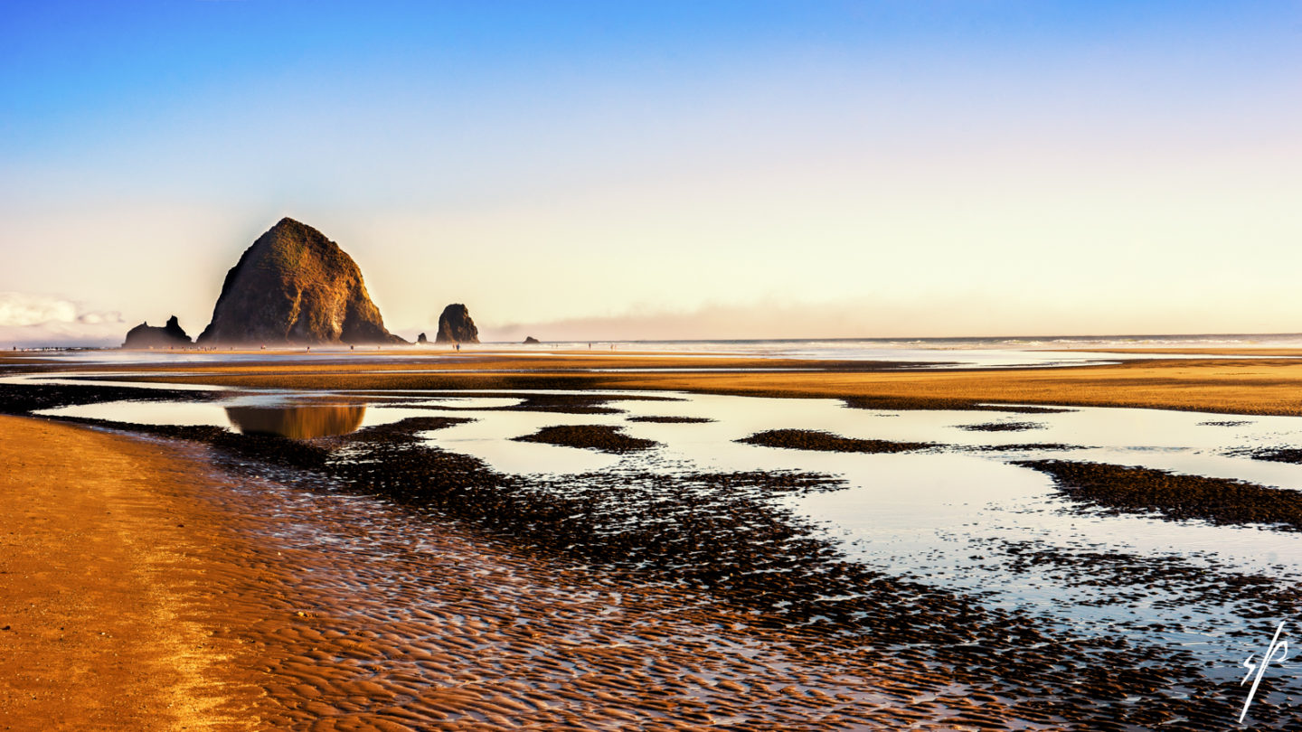 a beach with a rocky cliff in the background