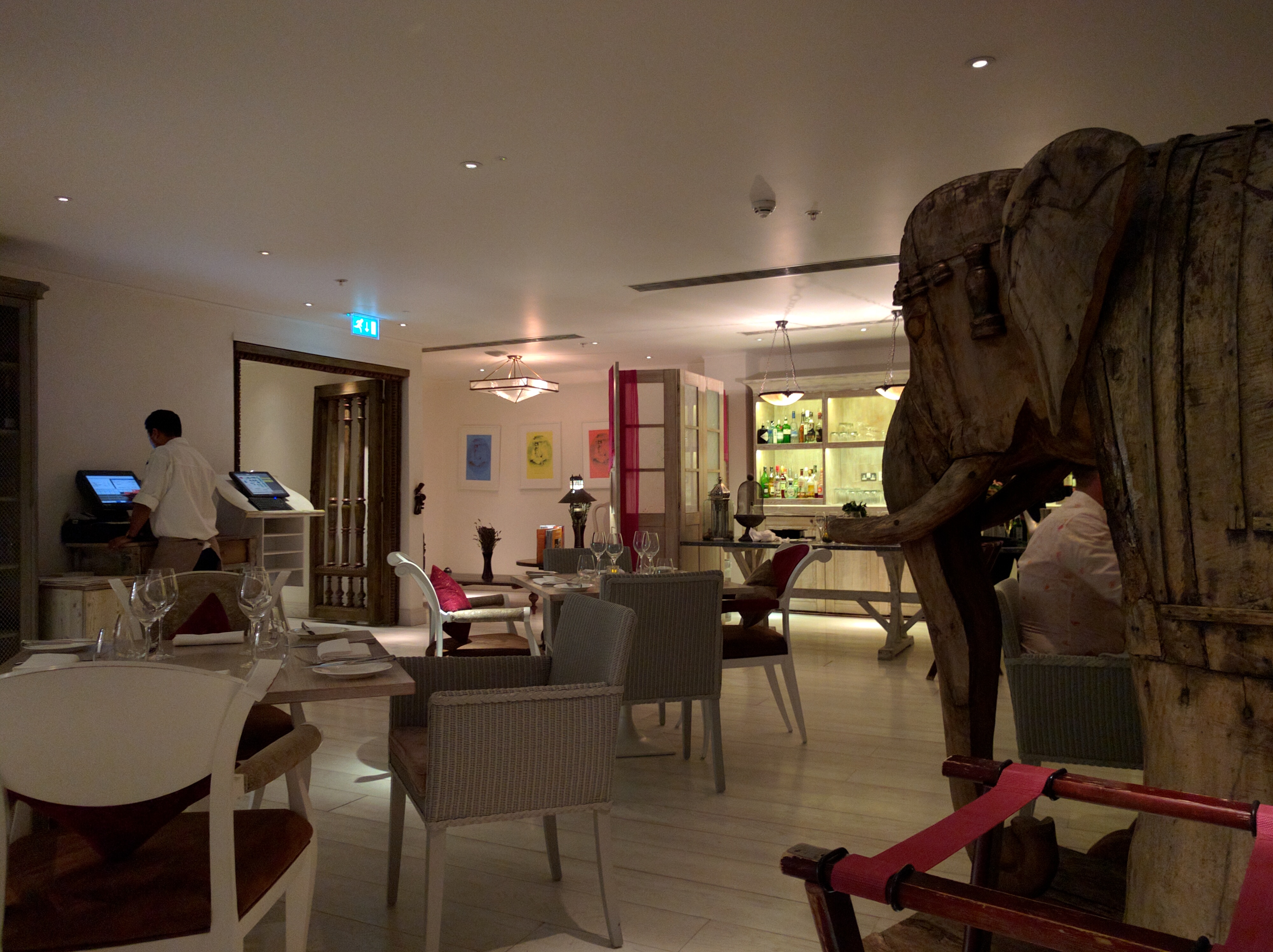 a room with a wooden elephant statue and chairs
