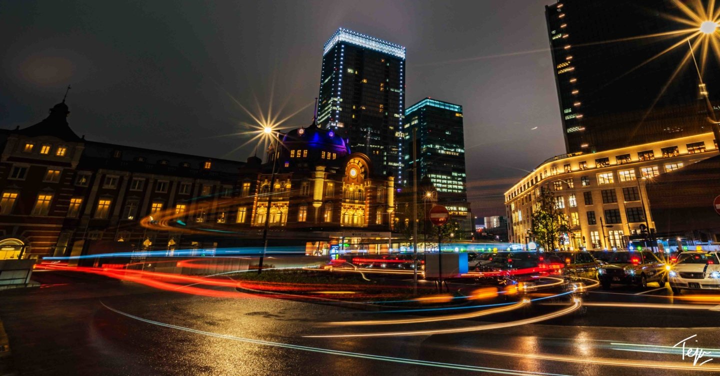 a city street with cars and buildings at night
