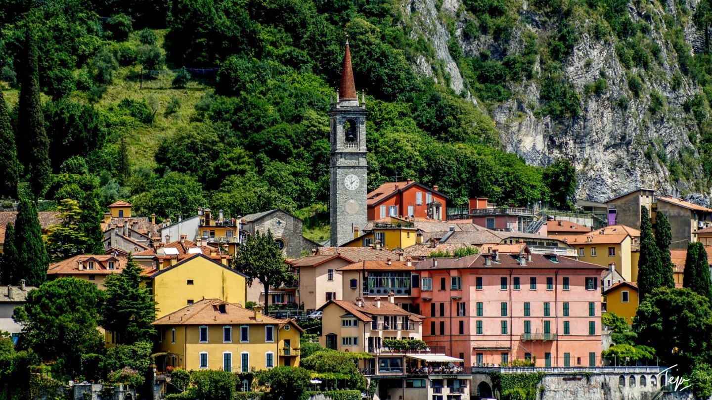 a group of buildings with a tower in the background