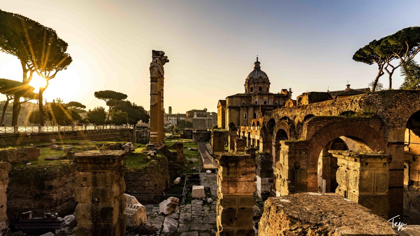 ruins of a building with a dome in the background