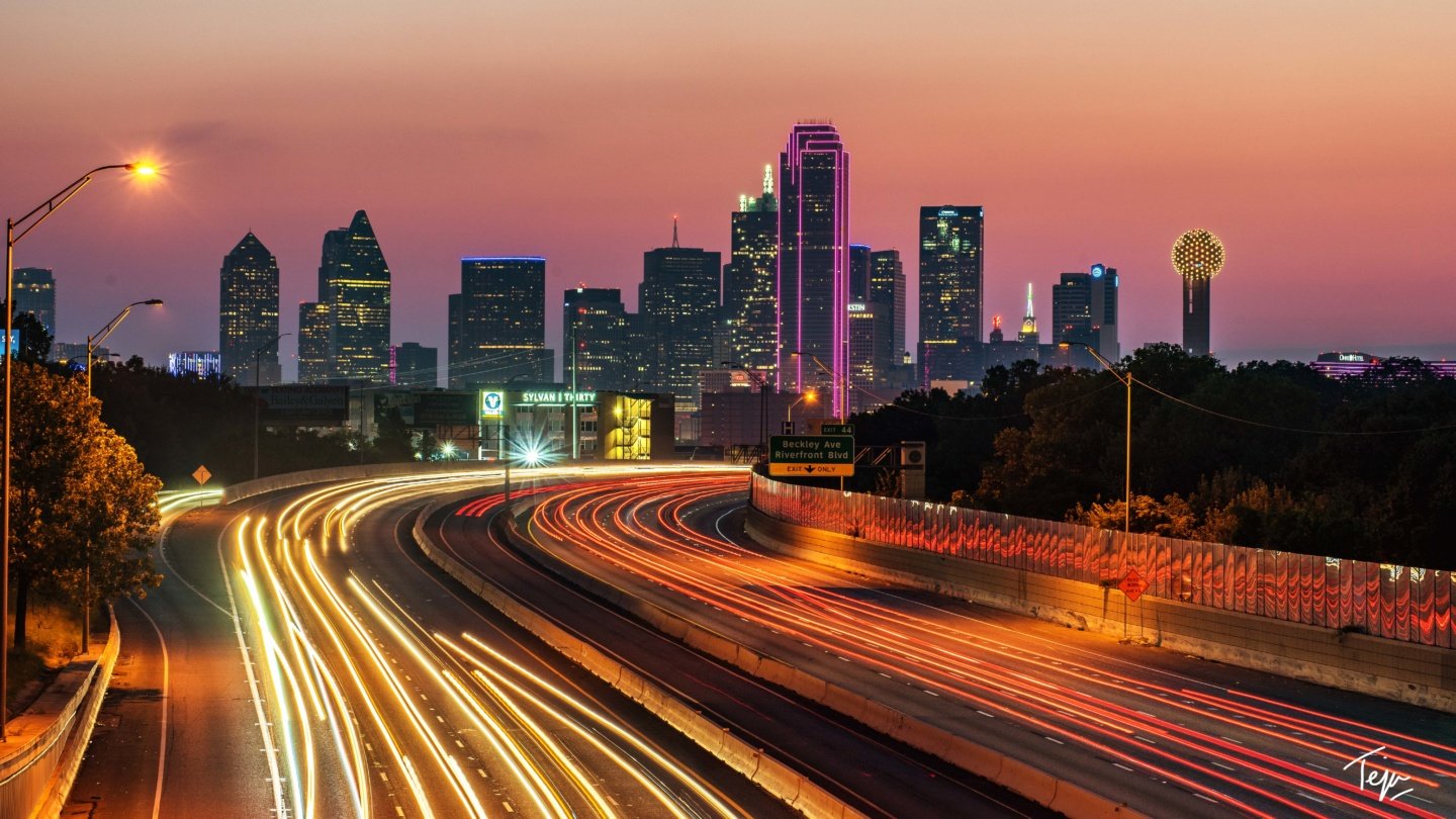 a city skyline with lights on the highway