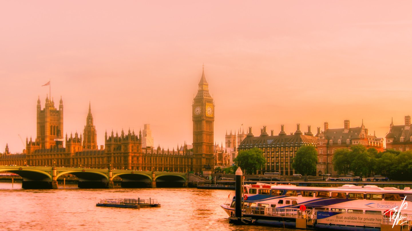a river with boats and a clock tower in the background