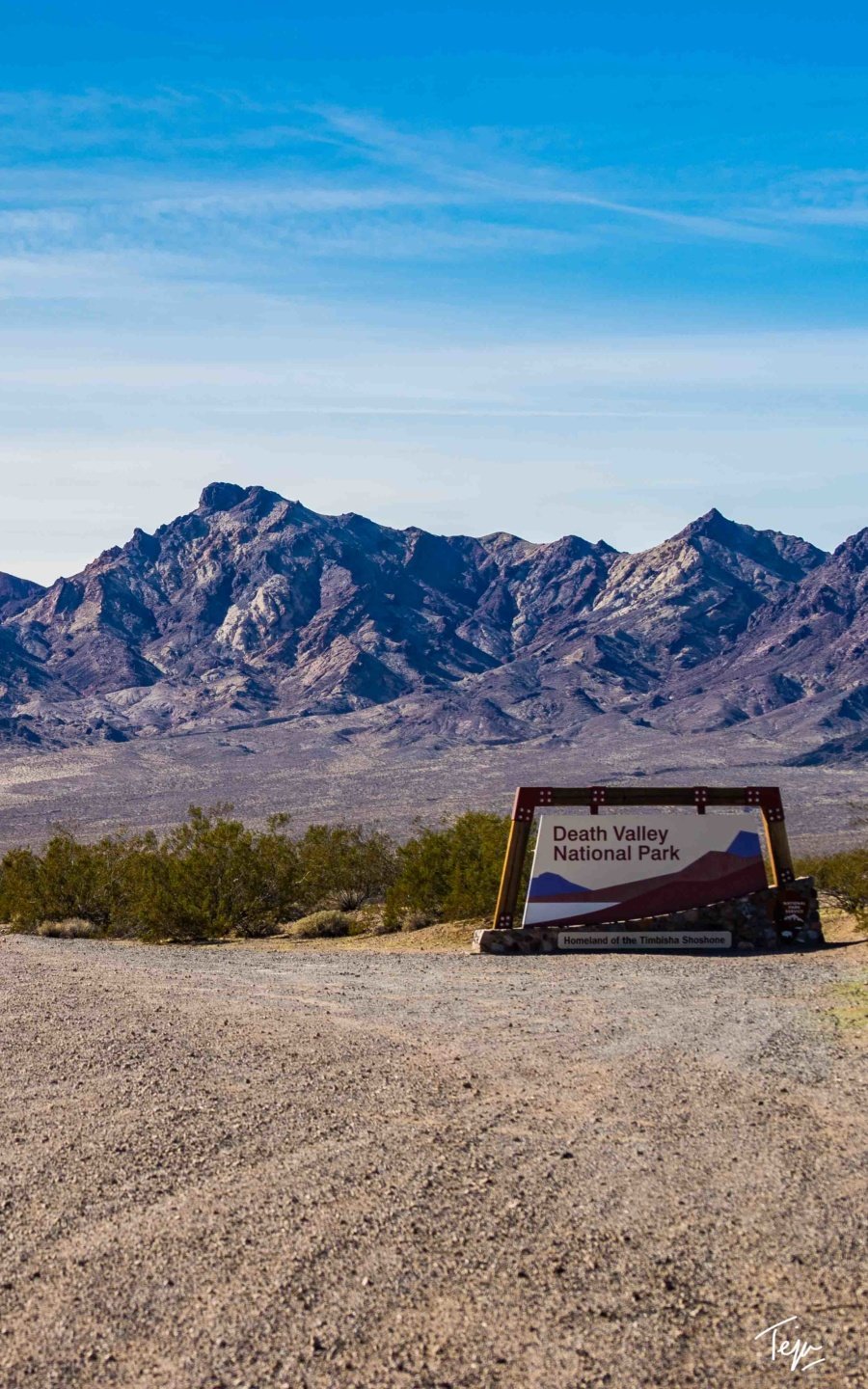 a sign in front of mountains