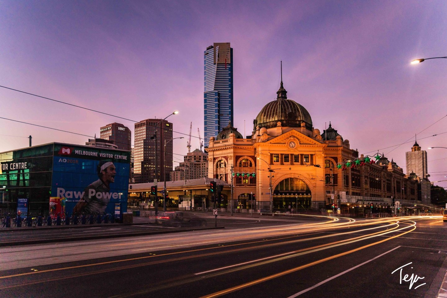 a city street with a large building and a billboard