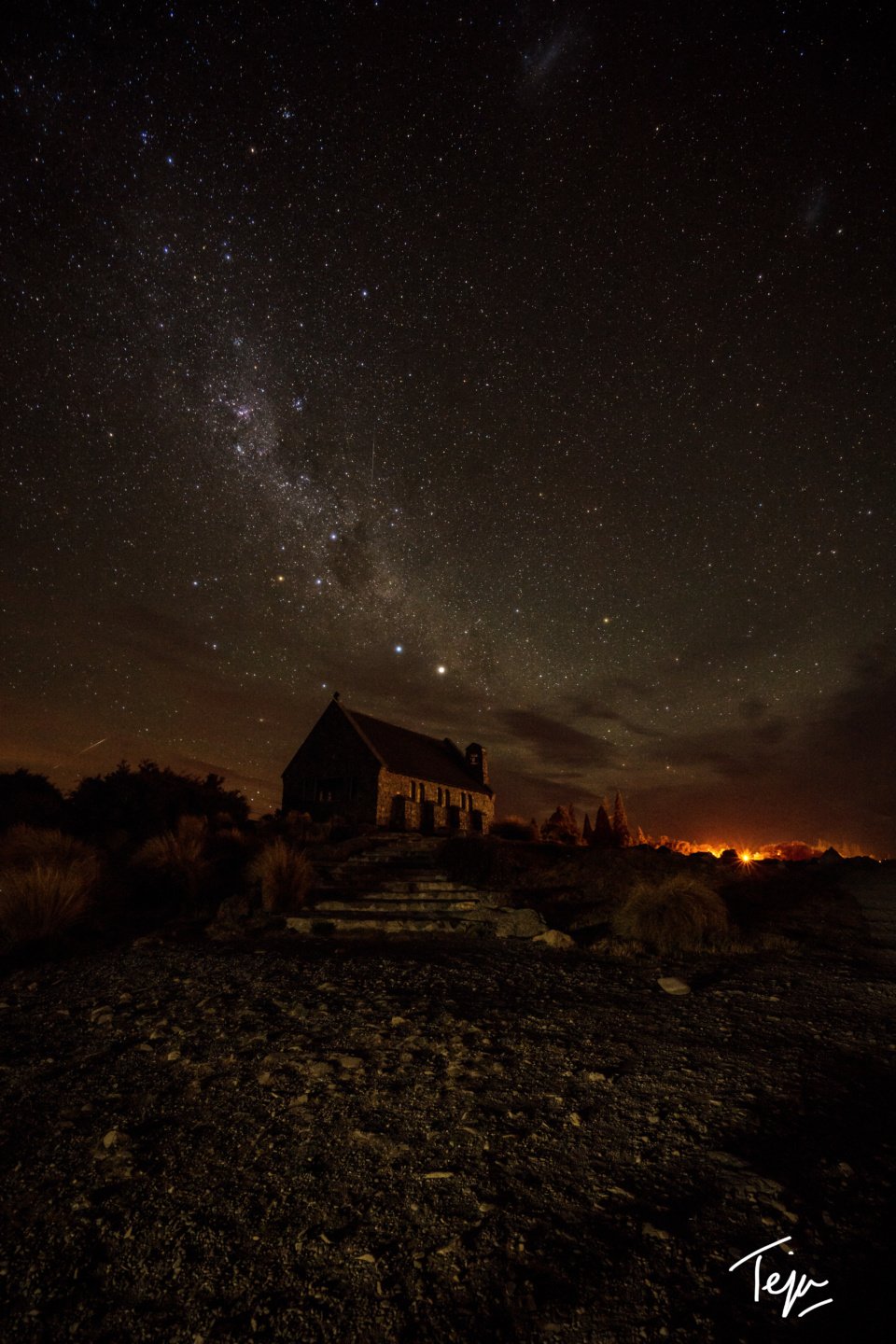a house with a stone building and a starry sky