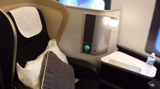 a seat with a pillow and a lamp on the side
