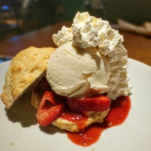 a biscuit with strawberries and whipped cream