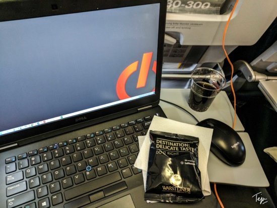 a laptop computer with a drink and a mouse