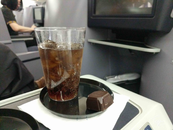 a glass of liquid with ice and chocolate on a tray