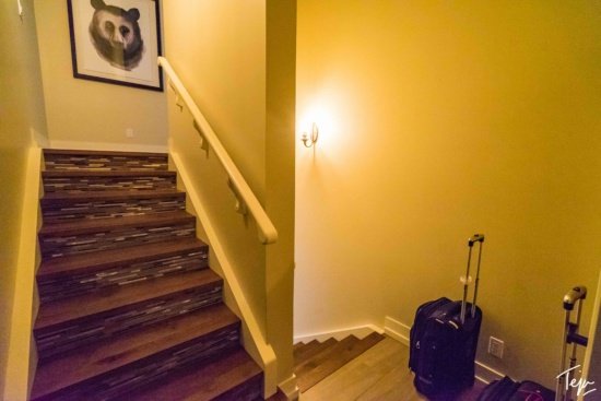 a staircase with a suitcase and a picture of a panda