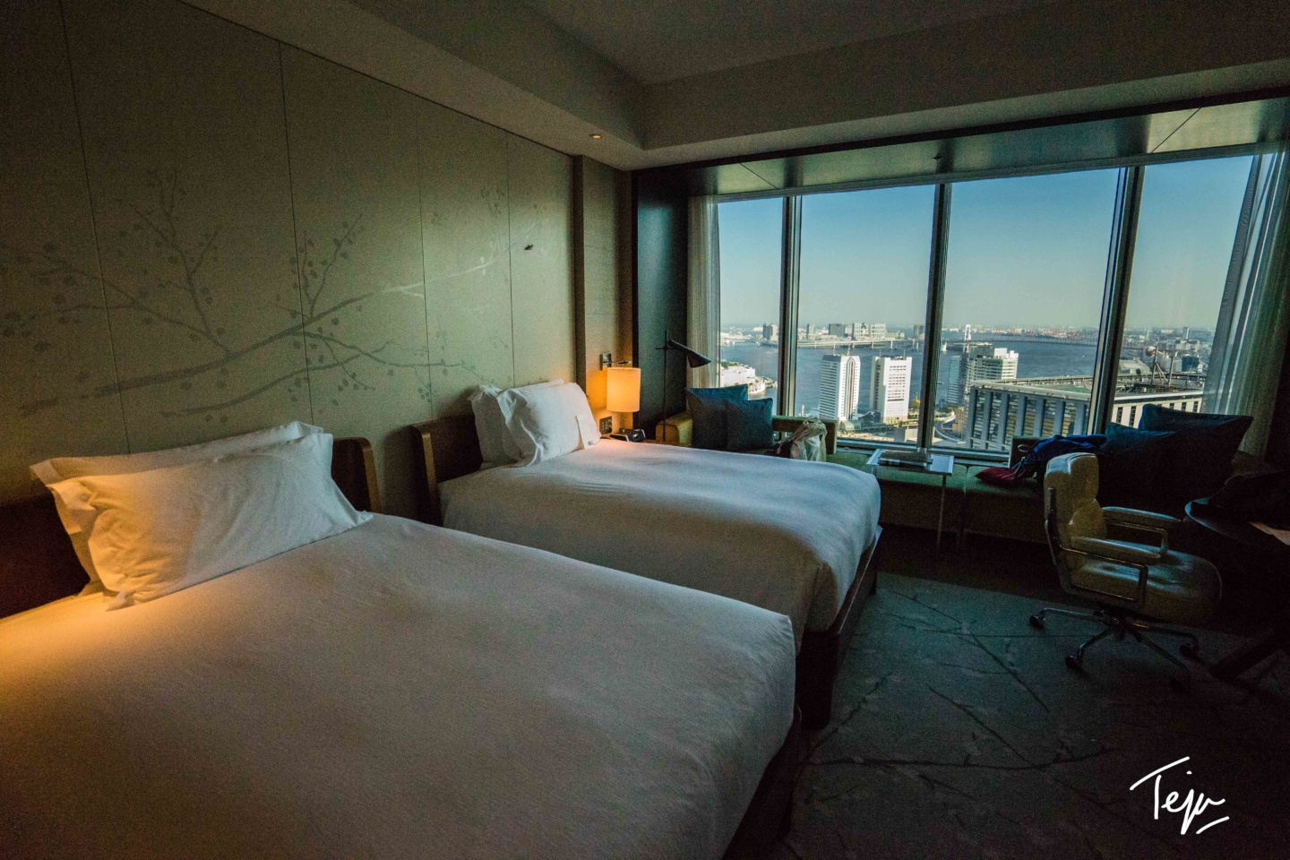 two beds in a room with a window and city view