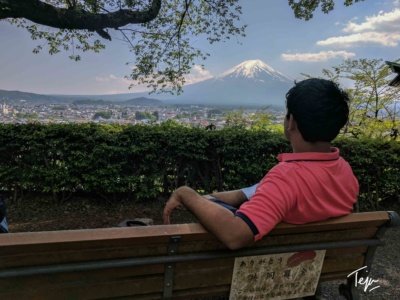 a man sitting on a bench looking at a mountain