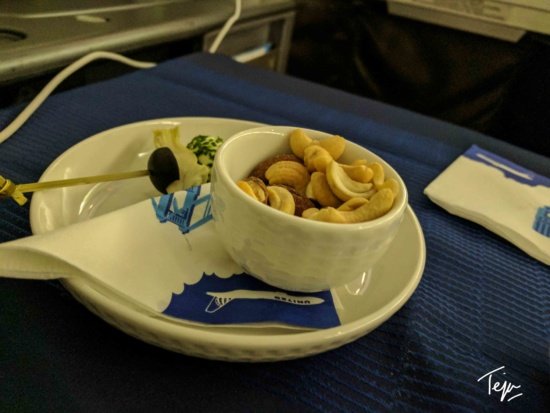 a bowl of nuts and a skewer on a plate