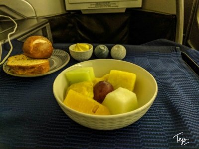 a bowl of fruit and bread on a table