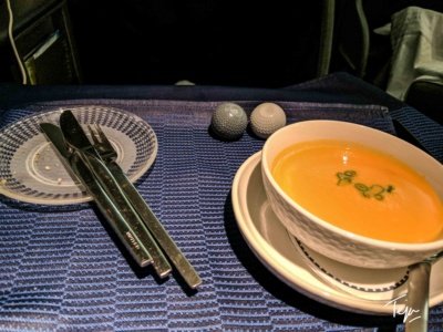 a bowl of soup and utensils on a table
