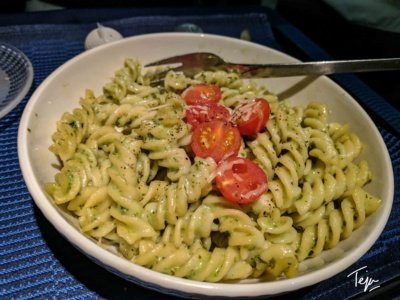 a bowl of pasta with tomatoes and a fork