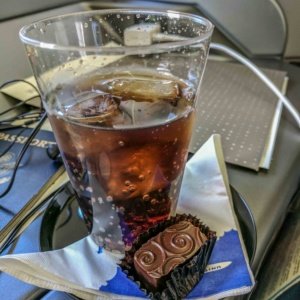 a glass of liquid and chocolate on a tray