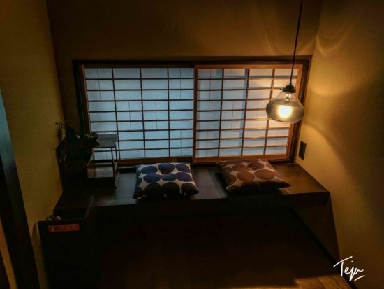 a window with paper blinds and a bench