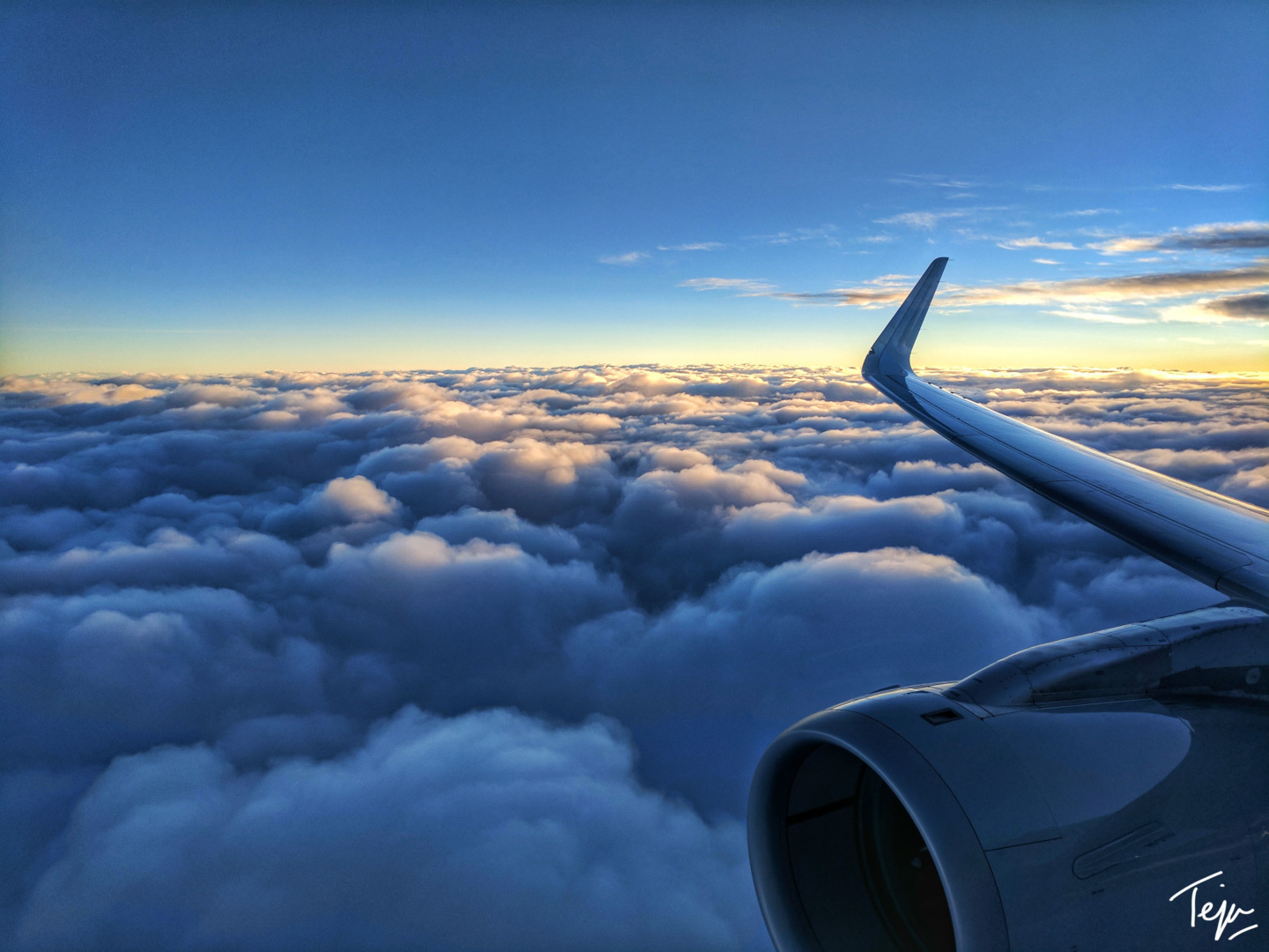 an airplane wing above the clouds