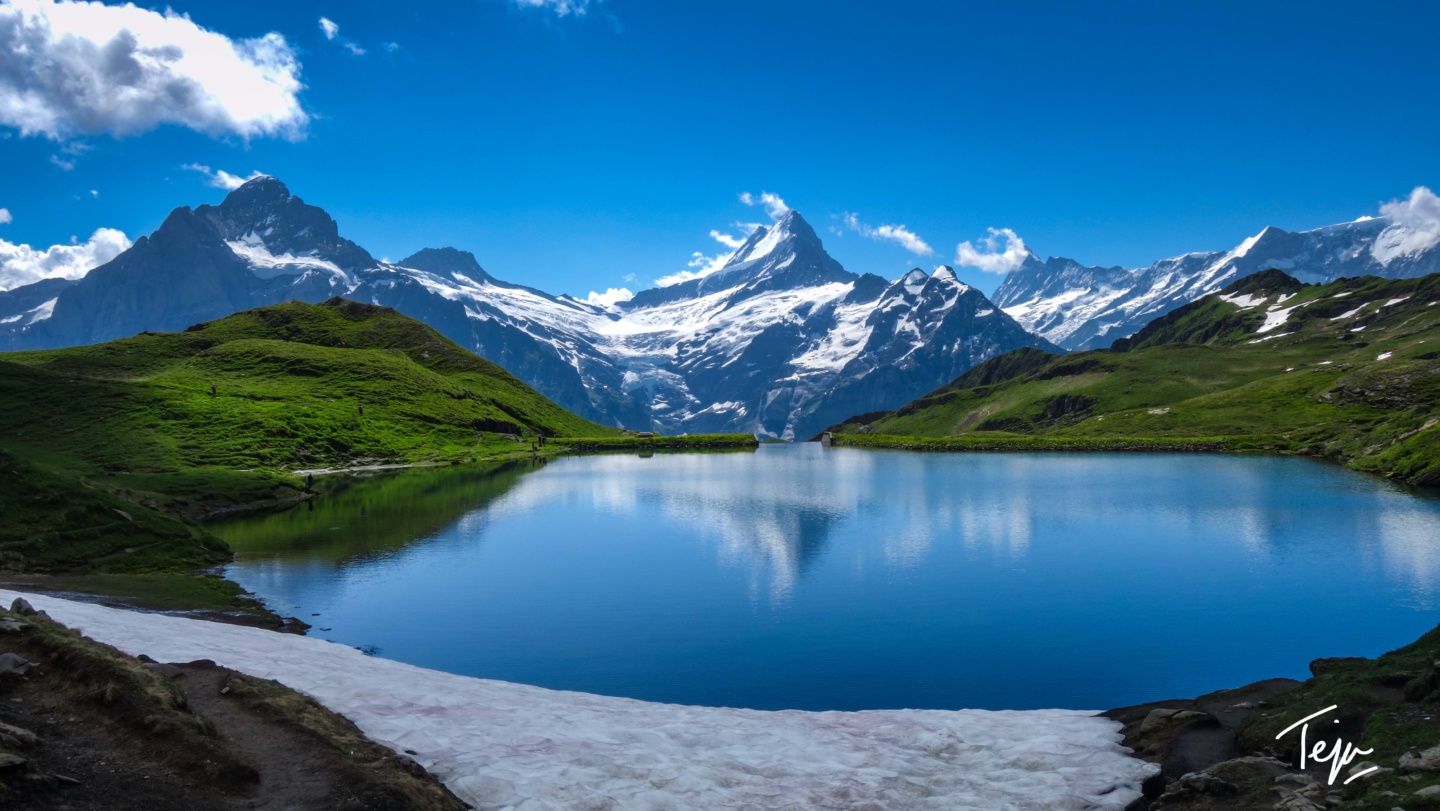 a lake surrounded by snow and mountains
