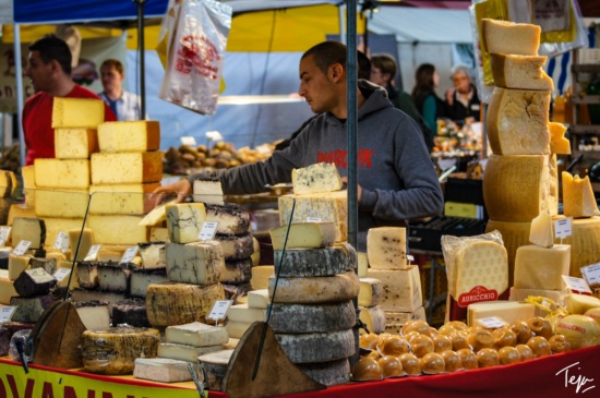 a man selling cheese at a market
