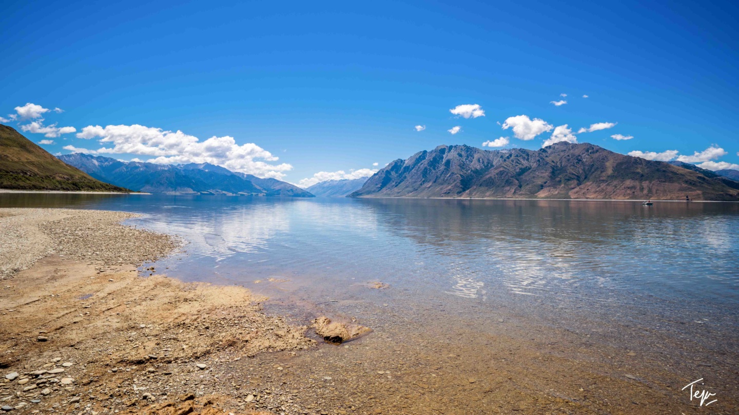 a body of water with mountains in the background