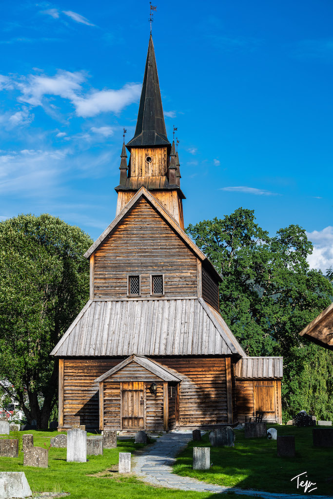 a wooden church with a steeple with Urnes Stave Church in the background