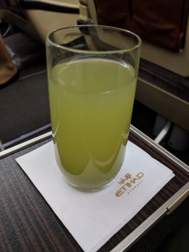 a glass of green liquid on a napkin