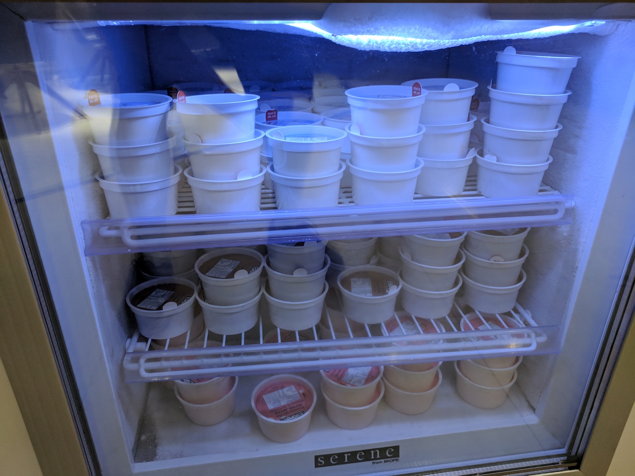 a refrigerator with many cups of yogurt
