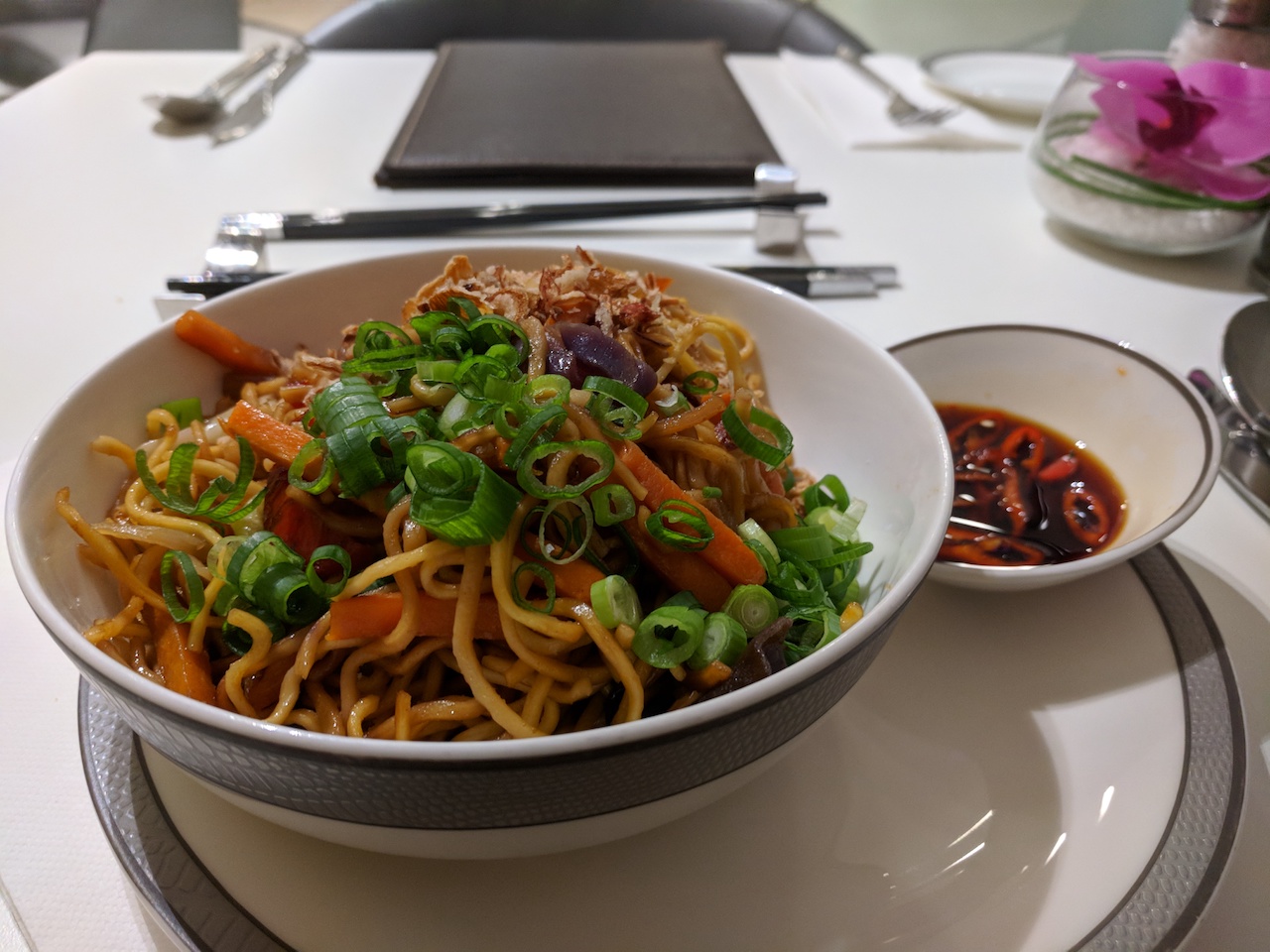 a bowl of noodles with vegetables and sauce