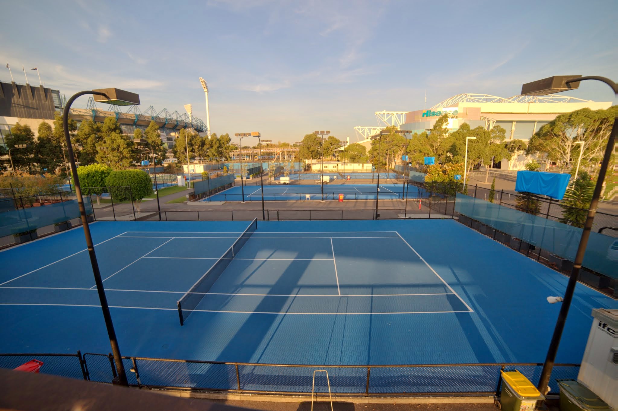 a tennis court with trees and a blue sky