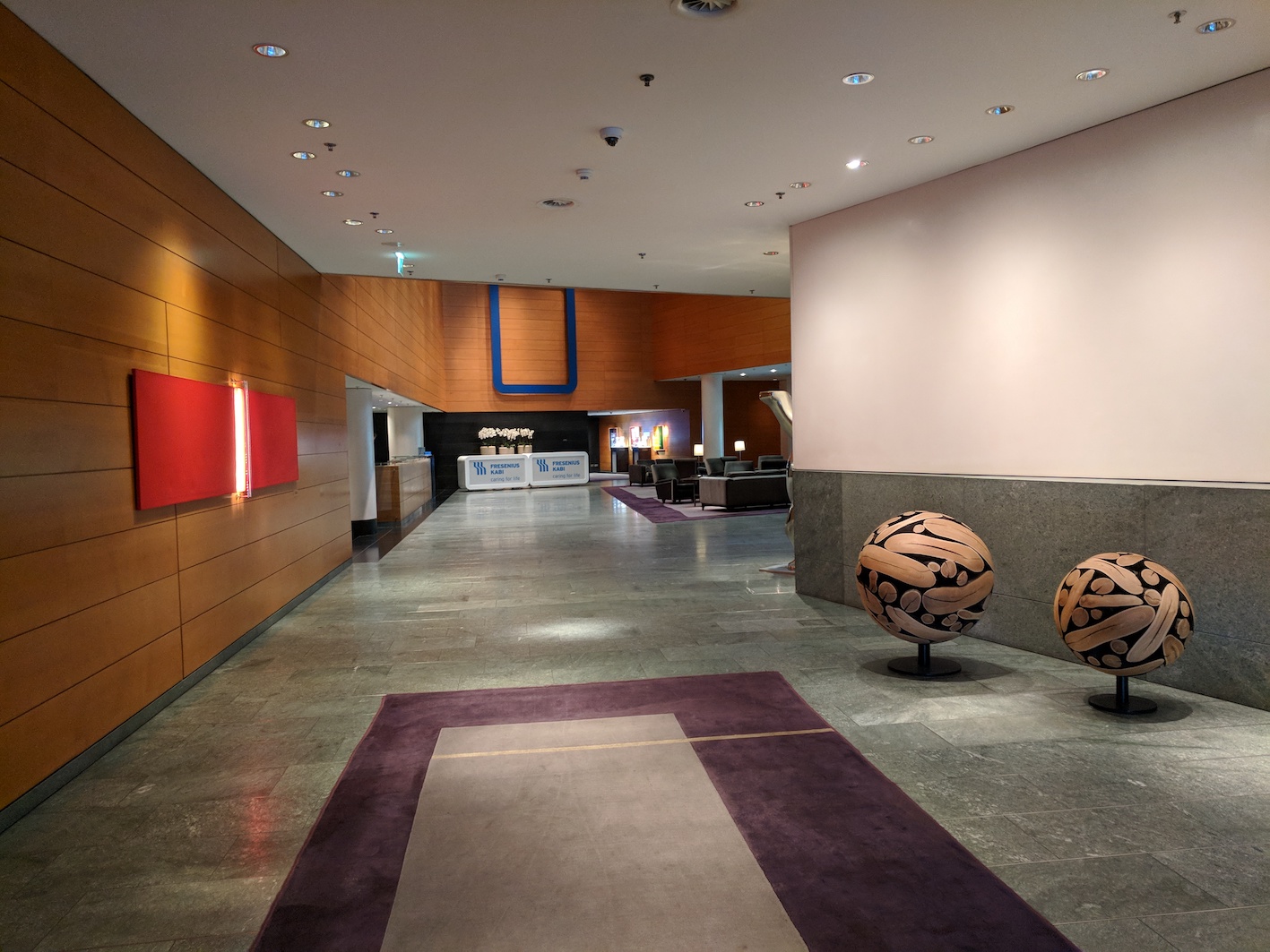 a lobby with two balls in front of a fireplace