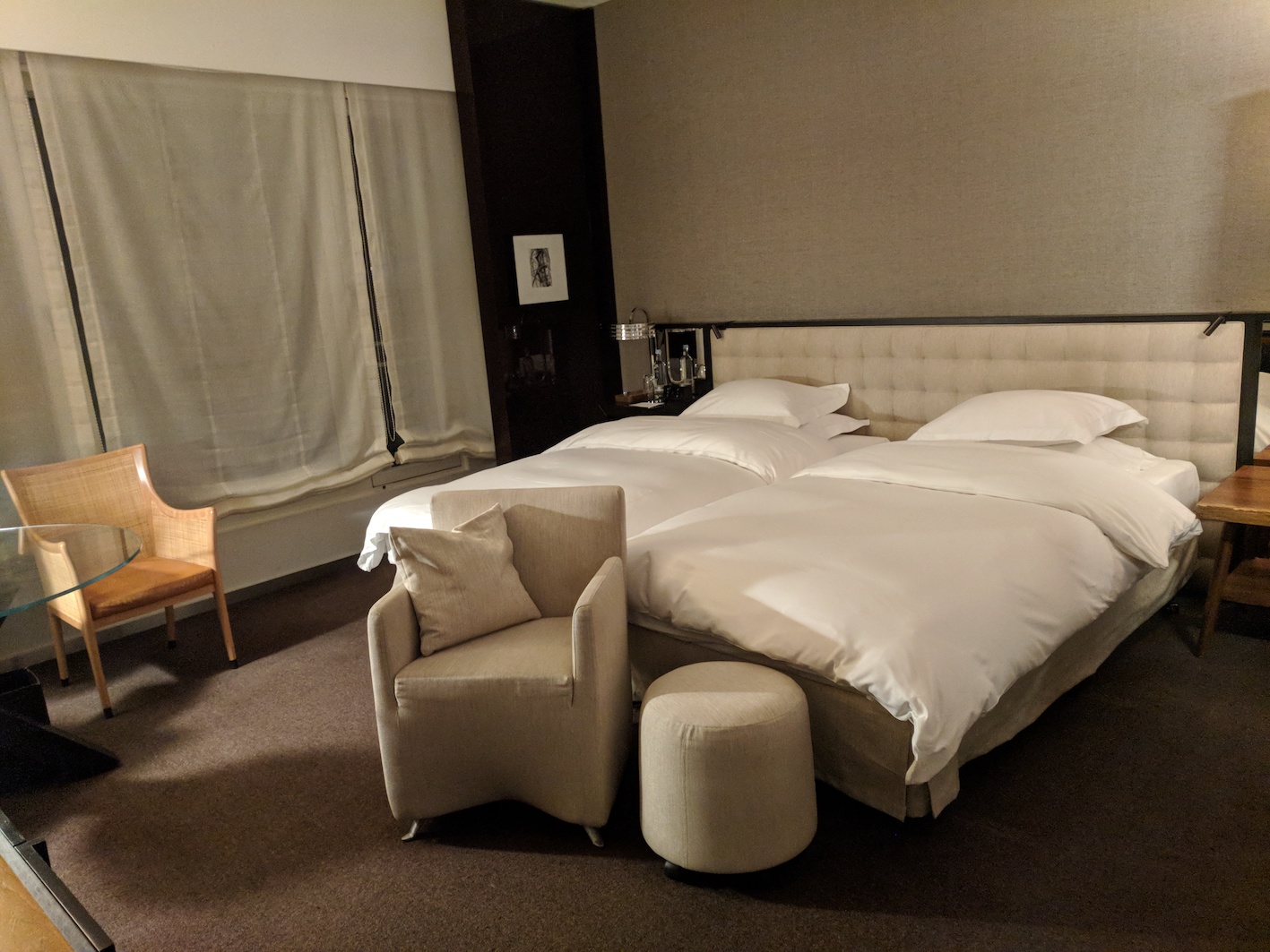 a bed with pillows and chairs in a room