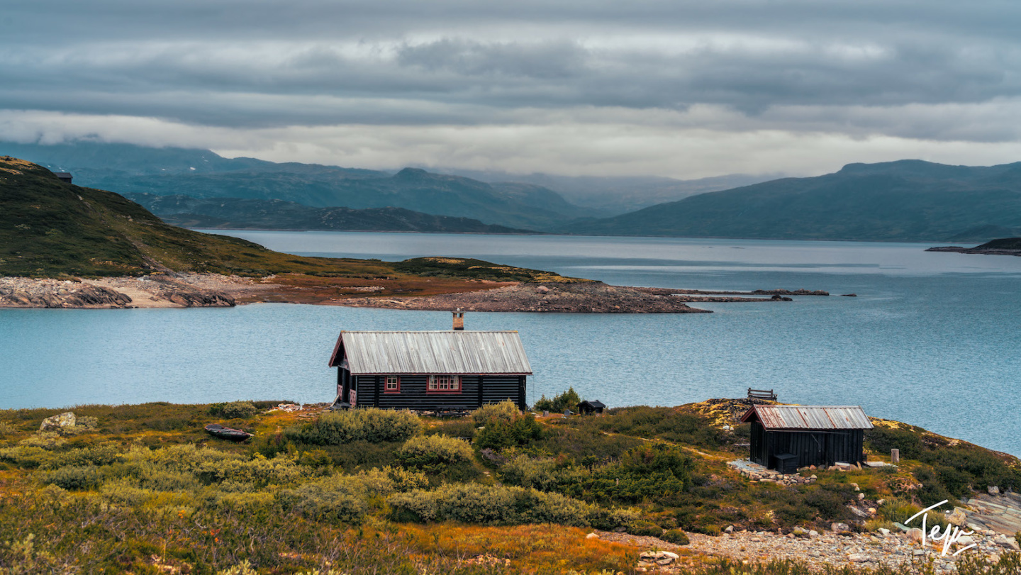 a house on a hill by a body of water