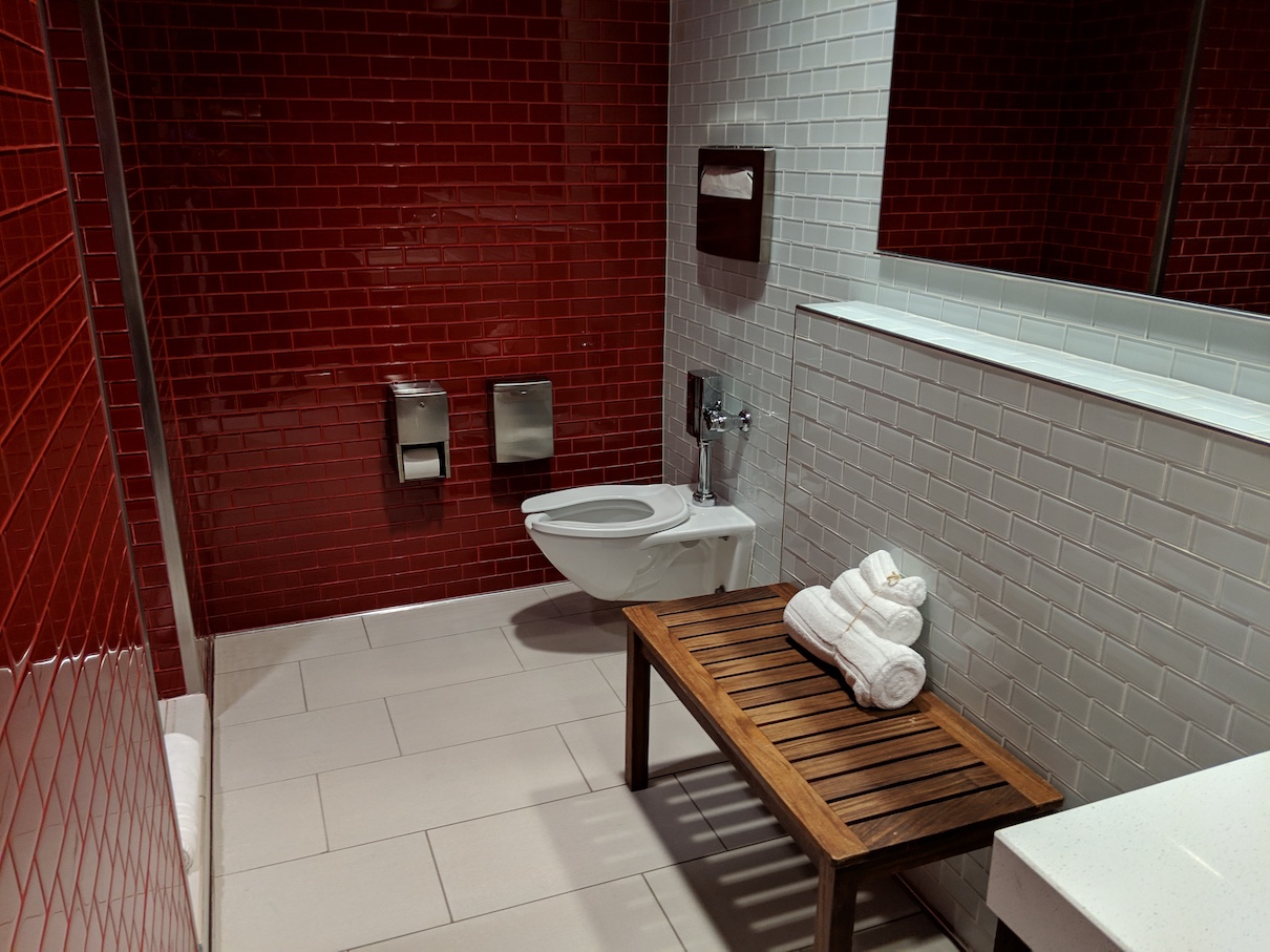 a bathroom with a toilet and a bench