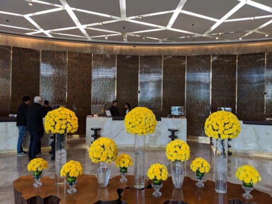 a group of yellow flowers in vases in front of a reception desk