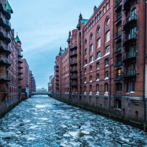 a river between buildings with ice