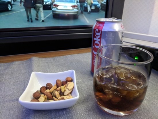 a bowl of nuts and a soda can next to a television