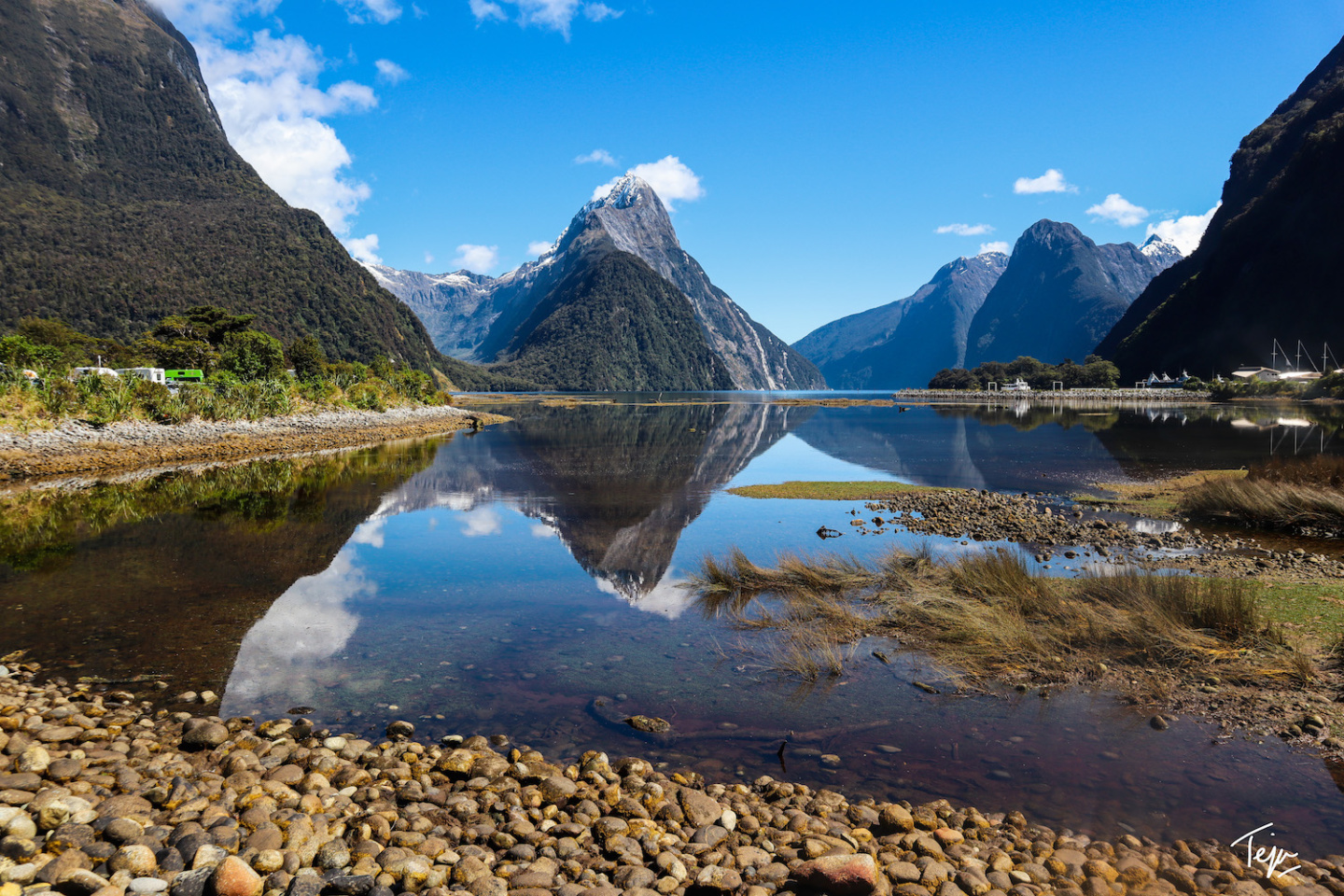 a body of water with mountains in the background with Milford Sound in the background