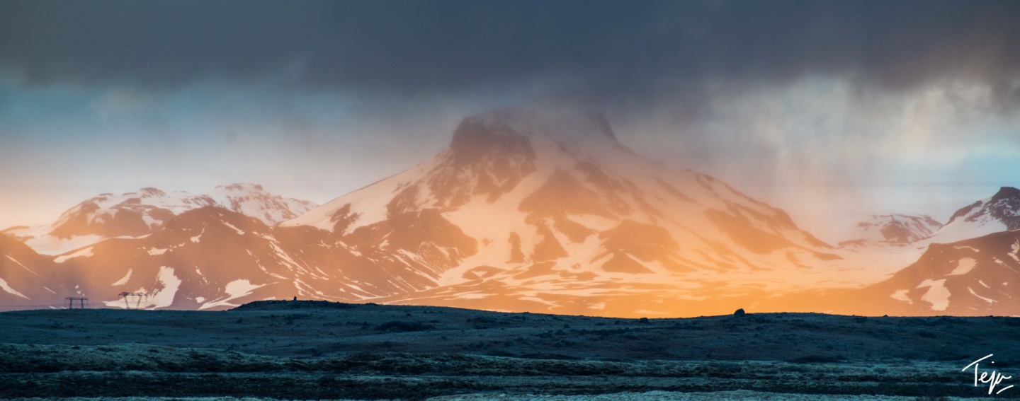 a snowy mountain with a cloudy sky