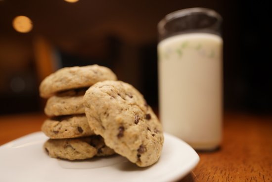 a stack of cookies on a plate next to a glass of milk