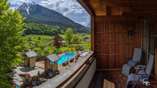 a view of a pool and mountains from a balcony