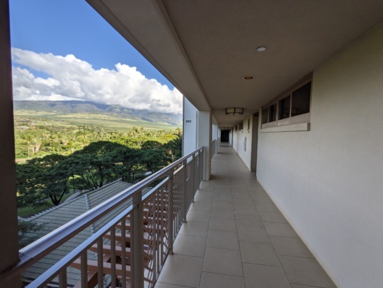 a long balcony with a view of a valley and mountains