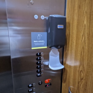 a hand sanitizer dispenser on a wall