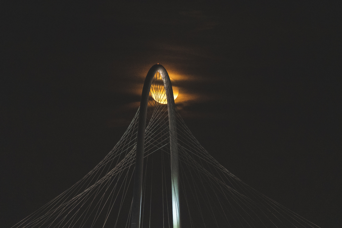 a bridge with a moon in the background