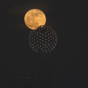 a moon behind a sphere