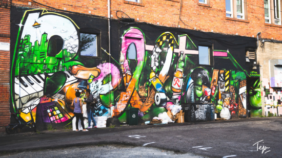 a group of people standing next to a wall with graffiti